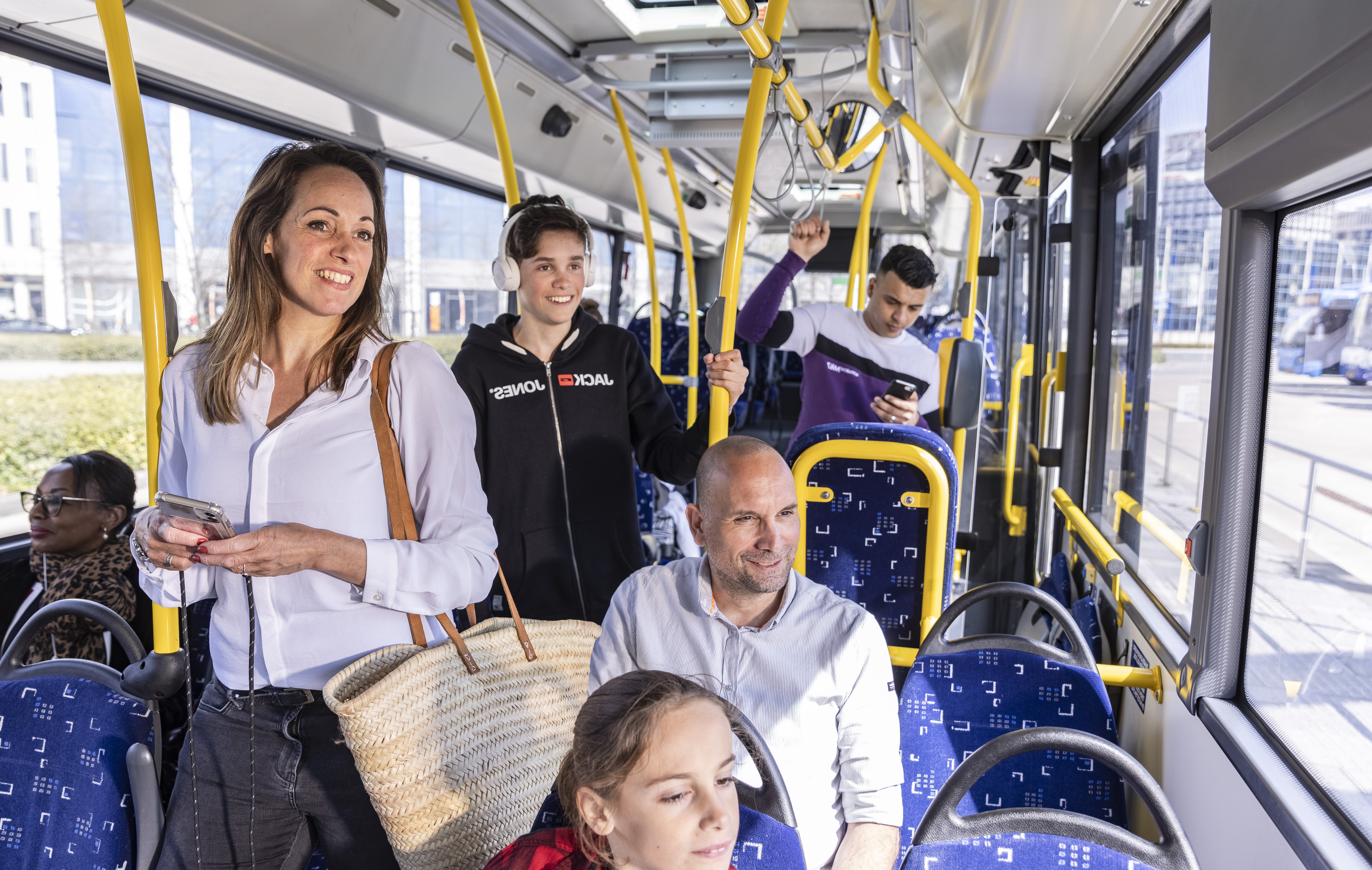 Mensen in een Arriva bus lachen en praten met elkaar