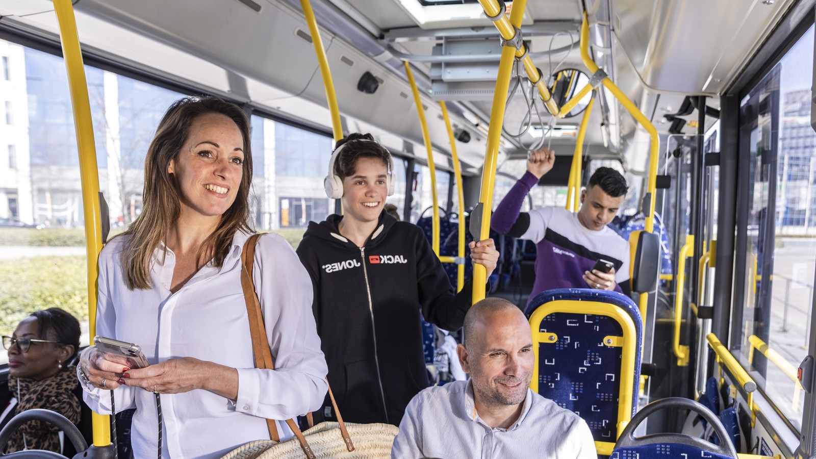 Reizigers in een bus van Arriva Mensen in een Arriva bus lachen en praten met elkaar